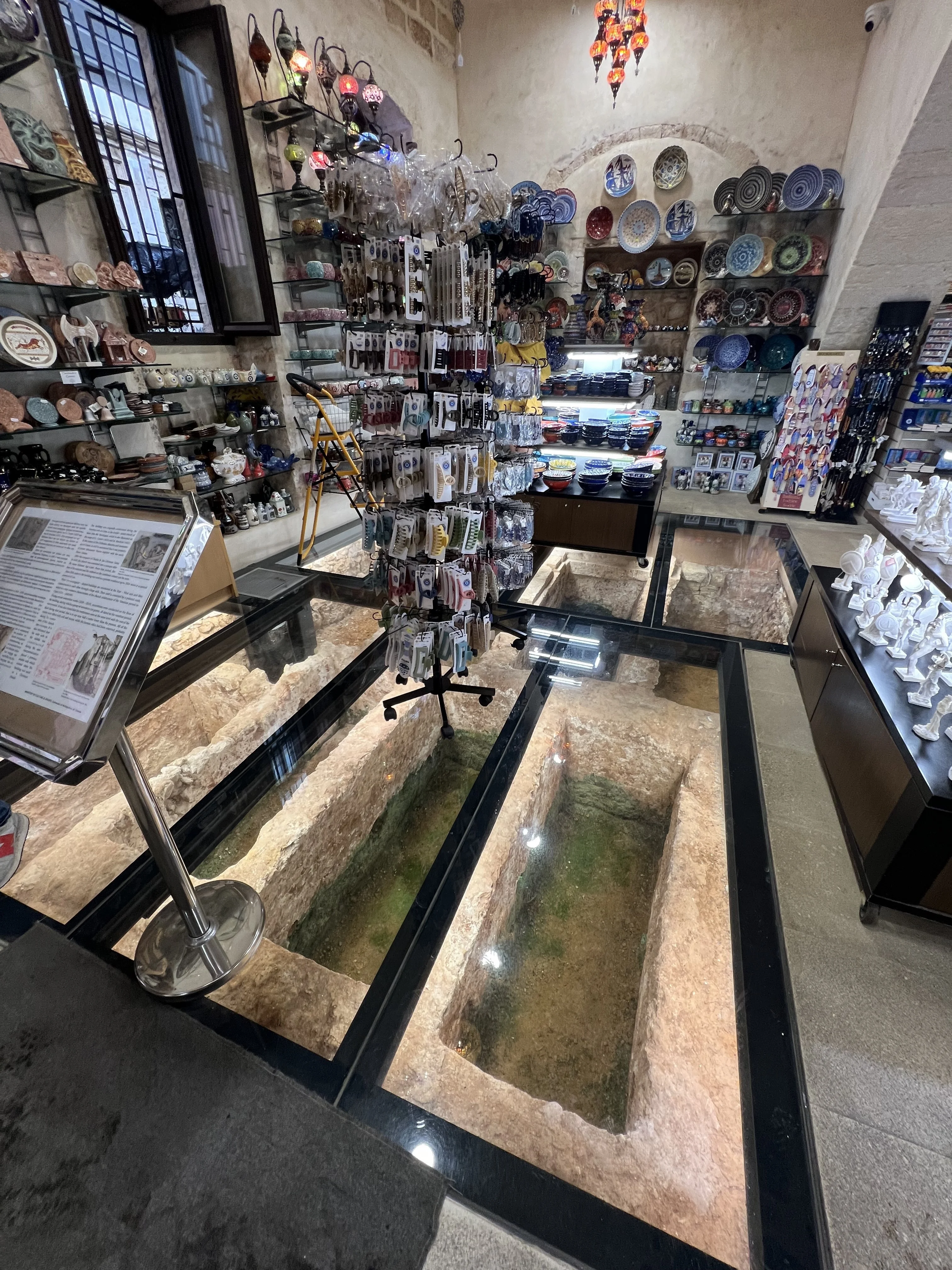 Ancient ruins visible beneath a glass floor in a Chania souvenir shop